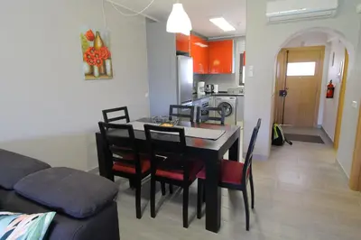 a kitchen and dining room with a table and chairs at Apartamento das Oliveiras in Albufeira