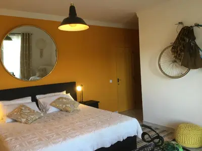 a bedroom with a bed with a mirror and a bicycle on the wall at Chambre d Hôte exclusif Naturiste et Nudiste CASA AMSYL adultes only in Paderne