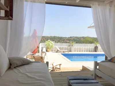 a living room with a view of a swimming pool at Chambre d Hôte exclusif Naturiste et Nudiste CASA AMSYL adultes only in Paderne