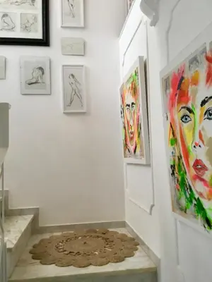 a hallway with art on the walls and a rug at Chambre d Hôte exclusif Naturiste et Nudiste CASA AMSYL adultes only in Paderne