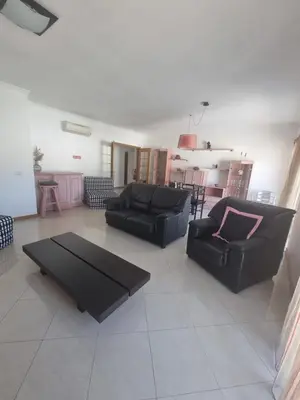 a living room with two black couches and a table at Albufeira Apart. T2 Baixa in Albufeira