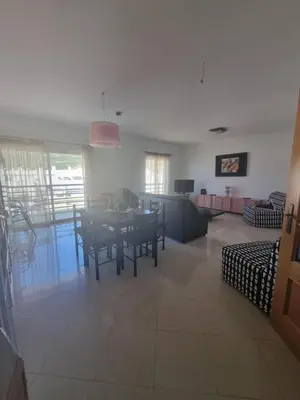 a dining room and living room with a table and chairs at Albufeira Apart. T2 Baixa in Albufeira