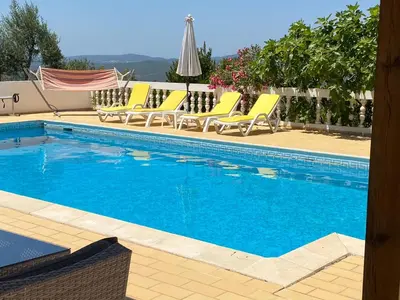 a swimming pool with yellow lounge chairs next to it at casa da ainheira 44 cruz da assumada 8100-296 Loulé in Loulé