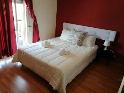 a bedroom with a white bed with a red wall at Guesthouse RSA by Umbral in Almancil