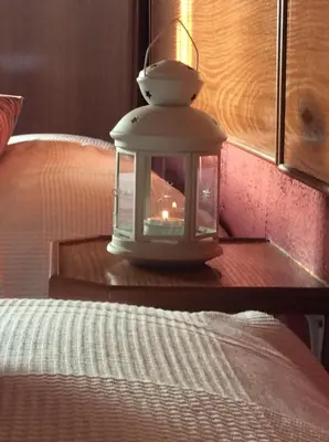 a lantern sitting on a table next to a bed at Guesthouse RSA by Umbral in Almancil