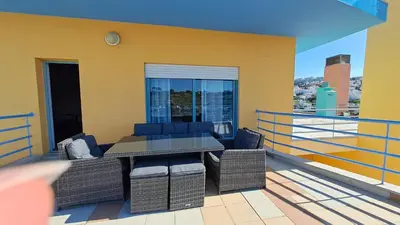 a balcony with a table and chairs on a roof at Albufeira Marina Penthouse 1 in Albufeira