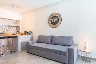 a living room with a couch and a clock on the wall at Villa Magna - Apt- 206 by HelloVacations in Albufeira