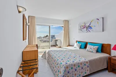 a bedroom with a bed and a large window at AZUL/MAR ALBUFEIRA 602 in Albufeira