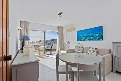 a kitchen and living room with a table and chairs at AZUL/MAR ALBUFEIRA 602 in Albufeira
