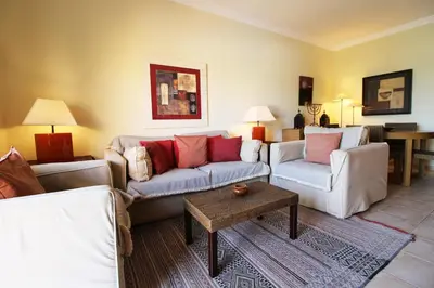a living room with two couches and a table at Apt T2 Jardins do Castelo - Albufeira, Algarve in Albufeira