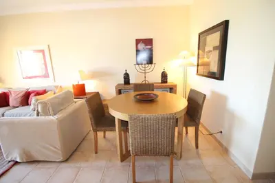 a living room with a table and a couch at Apt T2 Jardins do Castelo - Albufeira, Algarve in Albufeira