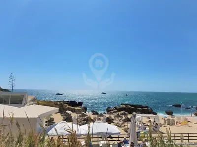 a beach with white umbrellas and the ocean at Apt T2 Jardins do Castelo - Albufeira, Algarve in Albufeira