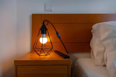 a lamp on a bedside table with a remote control at Villa Ruana - 5 bedrooms on Suite- Free out door Hot Jacuzzi - By Bedzy in Albufeira