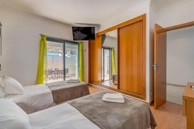 a hotel room with two beds and a balcony at Villa Ruana - 5 bedrooms on Suite- Free out door Hot Jacuzzi - By Bedzy in Albufeira