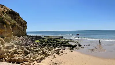 a beach with a bunch of rocks and the ocean at Medronheira by Check-in Portugal in Albufeira
