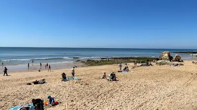 a group of people on a beach near the ocean at Medronheira by Check-in Portugal in Albufeira