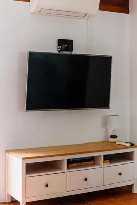a flat screen tv hanging on a white wall at Aldeia das Açoteias Apartment in Roja- Pé