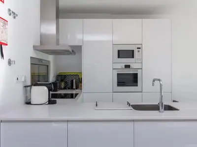 a kitchen with white cabinets and a sink at Harmony 4F House - Privat Heated Pool & Privacy & Albufeira in Albufeira