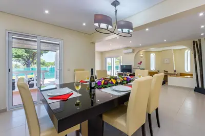 a dining room with a glass table and chairs at Villa Carlivo in Albufeira