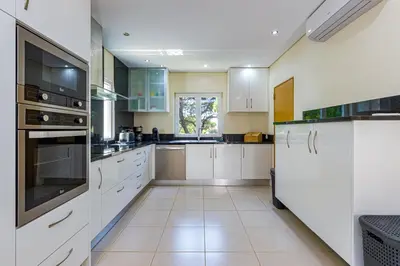 a large kitchen with white cabinets and appliances at Villa Carlivo in Albufeira