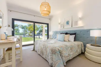 a bedroom with a bed and a desk and a window at Villa Casinha in Albufeira