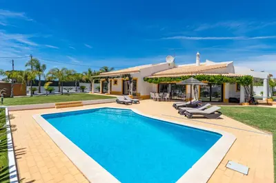 a swimming pool in front of a house at Villa Casinha in Albufeira