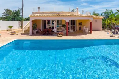 a villa with a swimming pool in front of a house at Villa Dolce Vita in Albufeira