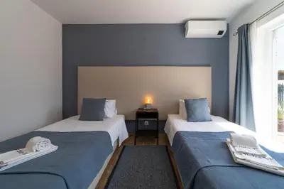 a bedroom with two beds and a window at Villa Dolce Vita in Albufeira