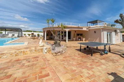 a house with a ping pong table in the yard at Villa Dolce Vita in Albufeira