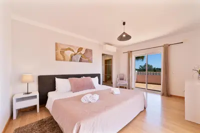 a bedroom with a large bed with two towels at Villa Duma in Albufeira