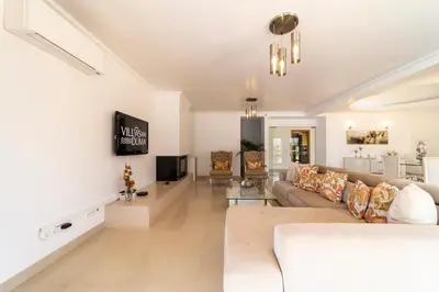 a living room with a couch and a tv at Villa Duma in Albufeira
