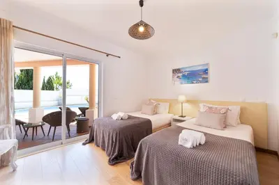 a hotel room with two beds and a balcony at Villa Duma in Albufeira
