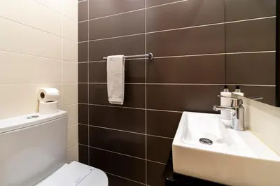 a bathroom with a white toilet and a sink at Villa Maria in Albufeira