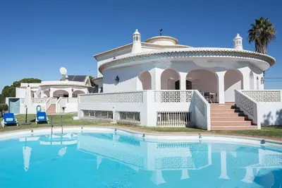 a large house with a swimming pool in front of it at Villa Solar das Palmeiras in Albufeira