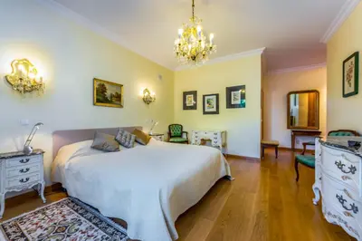 a bedroom with a large bed and a chandelier at Villa Cor de Rosa in Albufeira