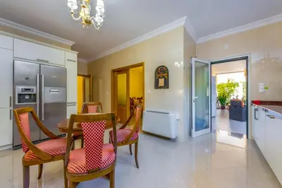 a kitchen and dining room with a table and chairs at Villa Cor de Rosa in Albufeira