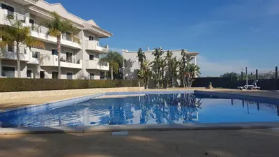 a swimming pool in front of a building at Quinta do Pinheiro Residence in Albufeira