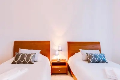 two beds sitting next to each other in a bedroom at Rei - Quarteira - 3 min to the beach in Vilamoura