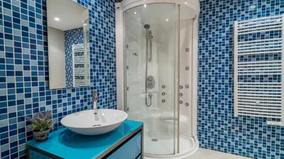 a blue tiled bathroom with a sink and a shower at Marina Vilamoura - Aquamar 120 - By Vilamoura Sun in Vilamoura