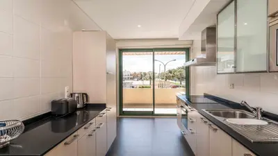 a kitchen with a sink and a large window at Marina Vilamoura - Aquamar 120 - By Vilamoura Sun in Vilamoura