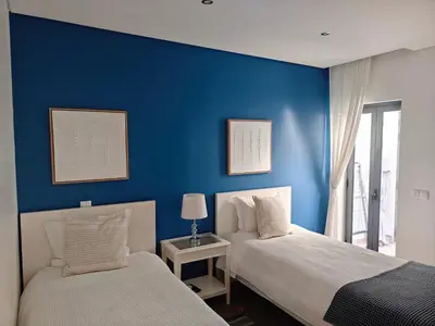 two beds in a room with a blue wall at The Old Town House by Freetimealgarve in Faro
