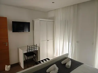 a bedroom with a bed and a desk and a television at The Old Town House by Freetimealgarve in Faro