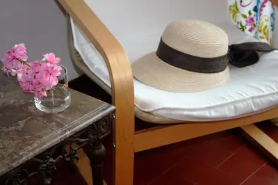 a hat sitting on a chair next to a table with flowers at Sunny Apartment Close to the Beach in Albufeira