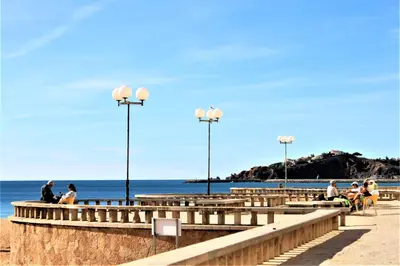 a group of people sitting on a pier near the ocean at Sunny Apartment Close to the Beach in Albufeira