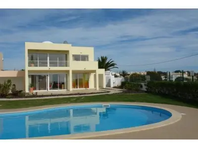 a house with a swimming pool in front of a house at Villas Oceano in Albufeira
