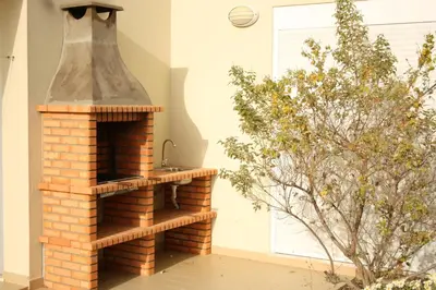 an outdoor brick oven in a room with a plant at Villas Oceano in Albufeira