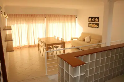 a living room with a table and a couch at Villas Oceano in Albufeira