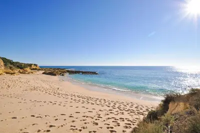 a building on the beach with the ocean in the background at Galé Mar by OCvillas in Galé