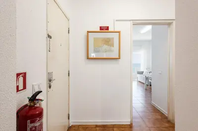 a hallway with a white door with a picture on the wall at Maresia - Front beach - Quarteira in Vilamoura