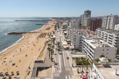 a view of a beach with buildings and the ocean at Maresia - Front beach - Quarteira in Vilamoura